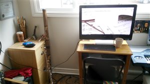 [Image of Kit Murley's instrument collection (including three ocarinas and a didgeridoo), flute, and all-in-one computer with tea mug sitting next to it.]